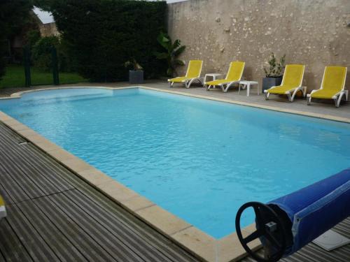 une grande piscine avec des chaises jaunes à côté dans l'établissement Gîte Moderne avec Piscine Chauffée entre Blois et Vendôme, Idéal Familles, Animaux Acceptés - FR-1-491-377, à Averdon