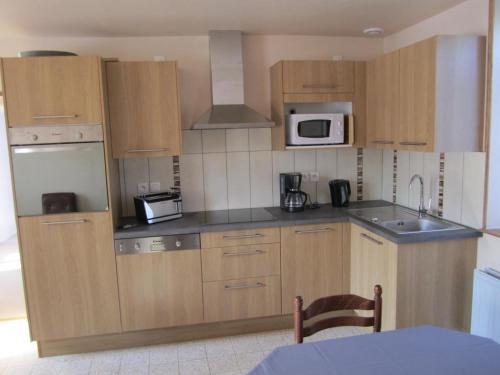 - une petite cuisine avec des armoires et des appareils en bois dans l'établissement Maison familliale près de Chaumont-sur-Loire : calme, bien équipée, idéale pour découvrir les Châteaux. - FR-1-491-379, à Chaumont-sur-Loire