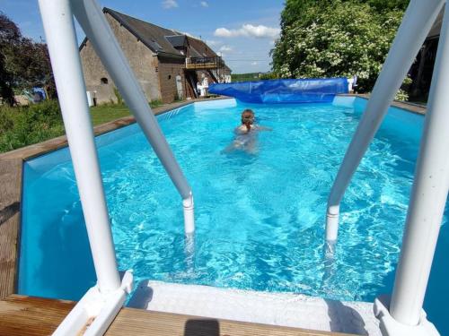 eine Person, die in einem blauen Pool schwimmt in der Unterkunft Gîte Prunay-Cassereau, 3 pièces, 4 personnes - FR-1-491-381 in Prunay-Cassereau