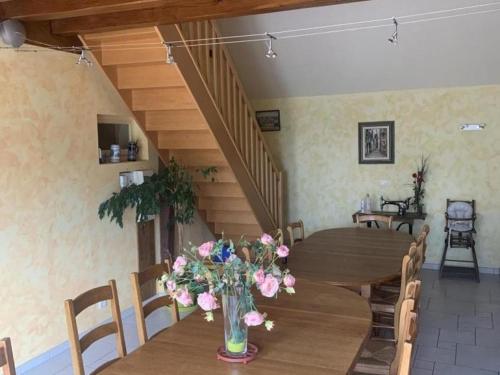 une salle à manger avec une table avec un vase de fleurs dans l'établissement Gîte avec Spa, Sauna, Jardin et Jeux - Proche Châteaux de la Loire - FR-1-491-397, à Mont-près-Chambord