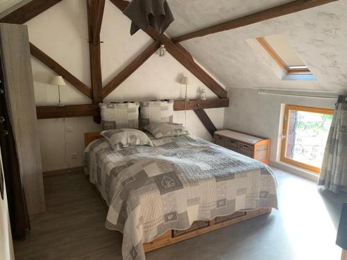 une chambre avec un grand lit dans un grenier dans l'établissement Gîte avec Spa, Sauna, Jardin et Jeux - Proche Châteaux de la Loire - FR-1-491-397, à Mont-près-Chambord