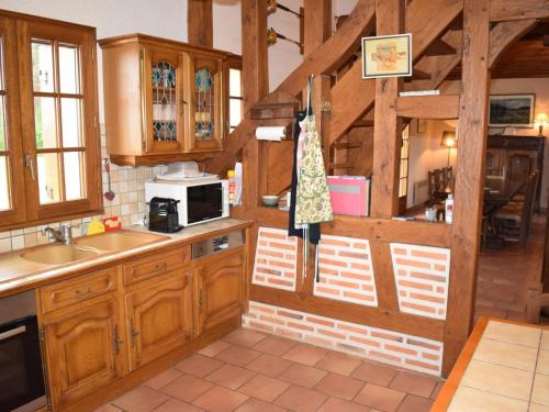 - une cuisine avec des placards en bois et un four micro-ondes dans l'établissement Lodge 9 chambres avec piscine chauffée, étang & activités au cœur de la Sologne - FR-1-491-384, à Fontaines-en-Sologne