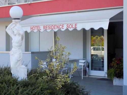 a white statue in front of a hotel residence suite at Hotel Residence Sole in Fontanafredda