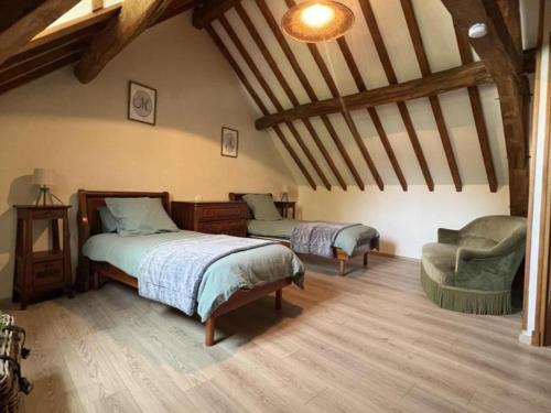 ein Schlafzimmer mit 2 Betten und einem Stuhl im Dachgeschoss in der Unterkunft Gîte Vallières-les-Grandes, 4 pièces, 6 personnes - FR-1-491-406 in Vallières-les-Grandes