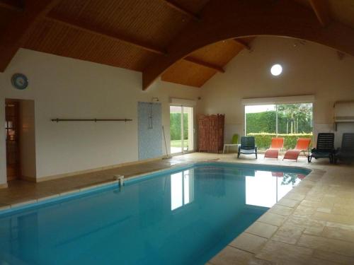 una grande piscina in una stanza con sedie di Maison avec piscine privative, proche châteaux de la Loire, 3 chambres, animaux acceptés, WiFi inclus - FR-1-491-413 a La Chapelle-Saint-Martin-en-Plaine