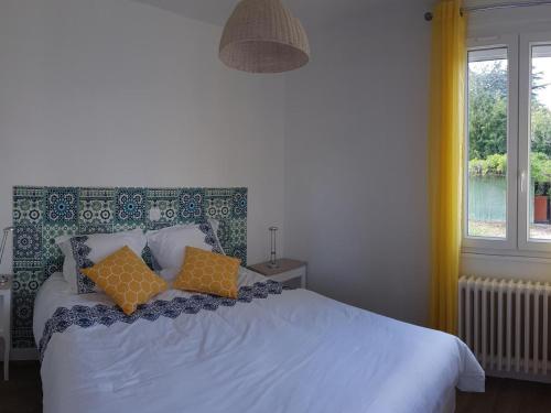 a bedroom with a bed with two pillows on it at Gîte confortable près de Chambord avec jardin et parking - FR-1-491-410 in Muides-sur-Loire