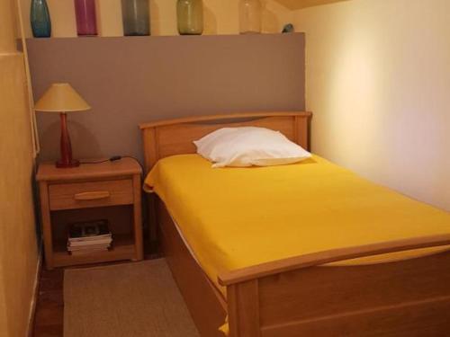 une petite chambre avec un lit jaune et une lampe dans l'établissement Gîte champêtre proche du Zooparc de Beauval, jardin privatif, vélos fournis, animaux acceptés - FR-1-491-405, à Pouillé