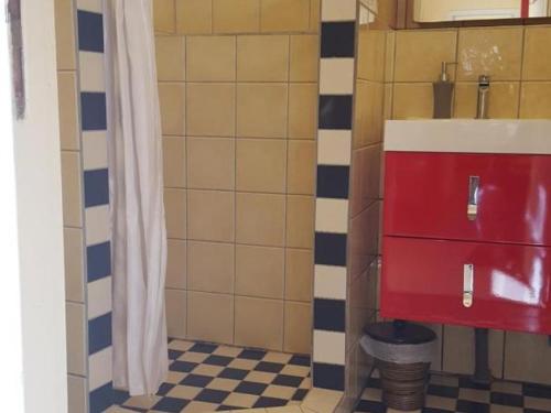 La salle de bains est pourvue d'une armoire rouge et d'un lavabo. dans l'établissement Gîte champêtre proche du Zooparc de Beauval, jardin privatif, vélos fournis, animaux acceptés - FR-1-491-405, à Pouillé