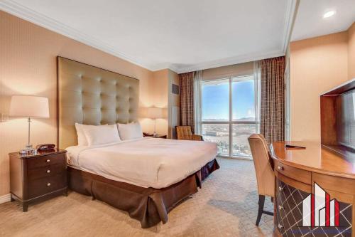 Un dormitorio con una cama, un escritorio y un televisor. en Signature 2BR3BA F1 View Balcony Ste 08-801 and 03, en Las Vegas