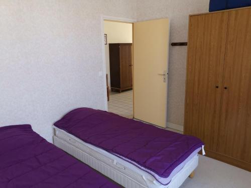 - une chambre avec un lit violet et un placard dans l'établissement Ancienne maison de maître rénovée, 6 pers, au cœur de la Sologne avec cour fermée et équipements modernes - FR-1-491-412, à Souvigny-en-Sologne