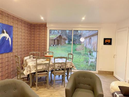 une salle à manger avec une table et des chaises et une fenêtre dans l'établissement Gîte de charme avec étang en Sologne, tout inclus, proche châteaux de la Loire et randonnées - FR-1-491-418, à Millançay