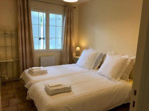 une chambre avec un grand lit blanc avec des serviettes dessus dans l'établissement Gîte familial de plain-pied avec grande terrasse, jardin clos et équipements complets à Vallières-les-Grandes - FR-1-491-423, à Vallières-les-Grandes