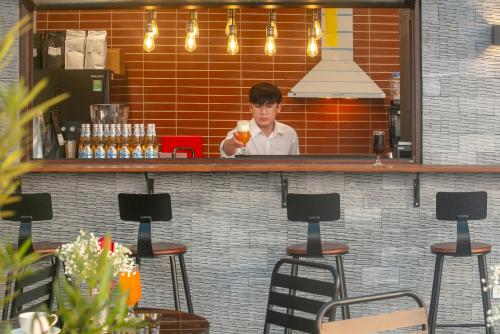 a man standing behind a counter in a restaurant at Pegasy Apartments & Travel in Hanoi