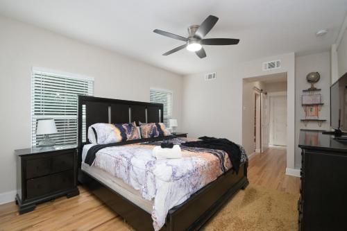 ein Schlafzimmer mit einem Bett und einem Deckenventilator in der Unterkunft The Marbled Speakeasy - San Antonio Luxury Home by the Alamo in San Antonio