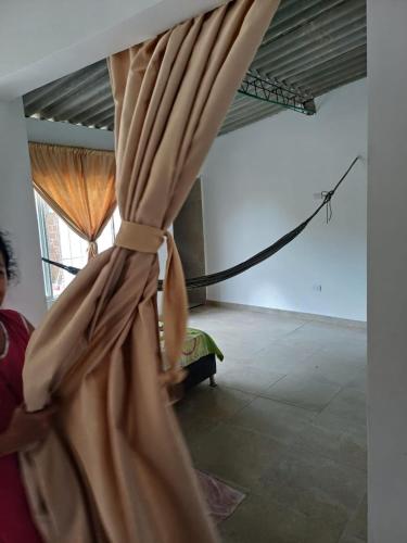 a woman is holding a curtain in a room at HABITACION PARA 2 PERSONAS COMODA in Valledupar