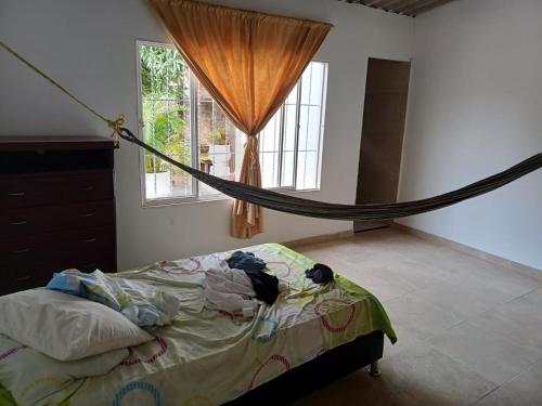 a bed with a hammock in a room with a window at HABITACION PARA 2 PERSONAS COMODA in Valledupar