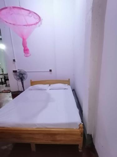 ein Schlafzimmer mit einem Bett mit einem rosa Ballon darüber in der Unterkunft Sobadahama ( The Nature Rest ) in Diwulankadawala