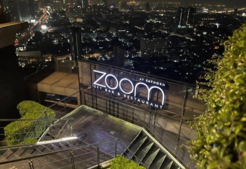 a sign on top of a building at night at Sathorn Prime Residence & Rooftop Sky Bar in Bangkok