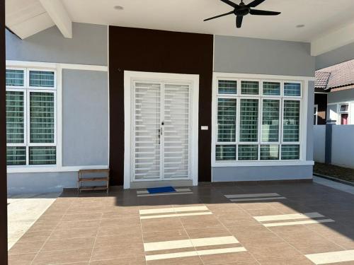 a room with a white door and a ceiling fan at Live Well Homestay Senawang in Seremban