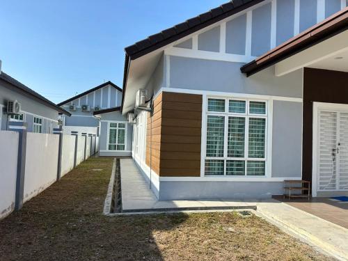 una casa bianca con una recinzione di fronte di Live Well Homestay Senawang a Seremban