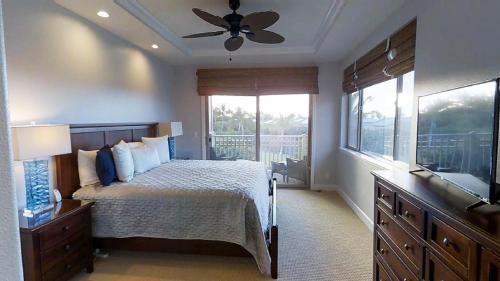 a bedroom with a bed and a ceiling fan at INSPIRATION VILLA Inspiring 2BR Kulalani Home with Private Beach Club in Waikoloa