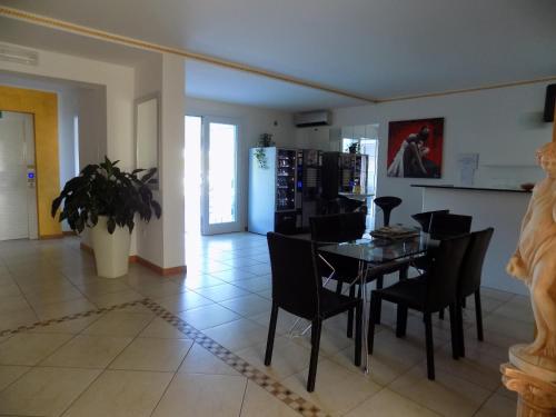 a dining room and kitchen with a table and chairs at Hotel Residence Sole in Fontanafredda