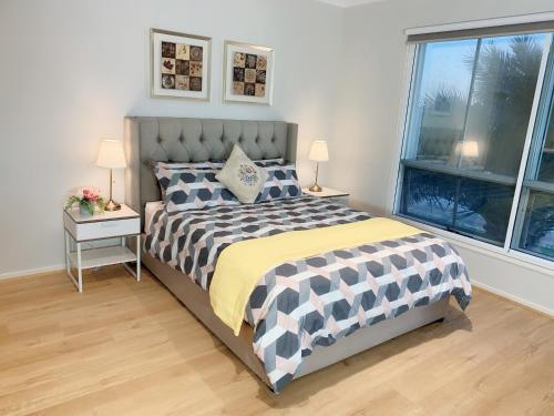 1 dormitorio con 1 cama, 2 lámparas y 2 ventanas en Designer Decor Home with 8Beds at Williams Landing, en Laverton