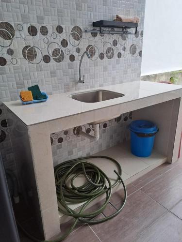 a kitchen counter with a sink and a hose at Live Well Homestay Senawang in Seremban