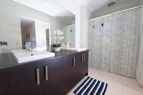 y baño con lavabo y ducha. en Designer Decor Home with 8Beds at Williams Landing, en Laverton