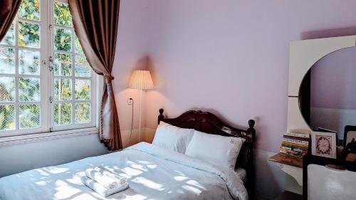 a bedroom with a bed and a window at Mộc Nhiên Villa in Da Lat