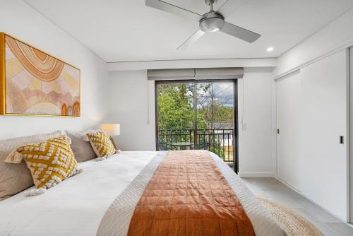 een slaapkamer met een bed en een plafondventilator bij 'Tropical Escape' Coastal Daydreams with Rooftop Spa in Palm Cove