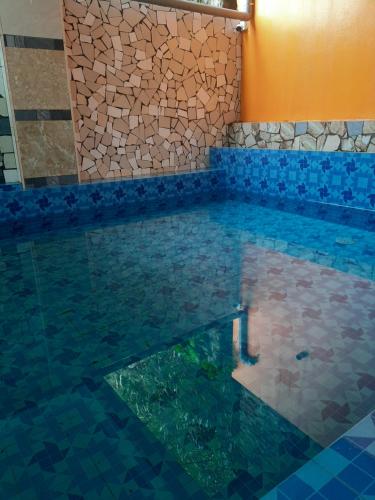 a pool in a house with a rock wall at Galaxy Hotel in Tam Ðảo