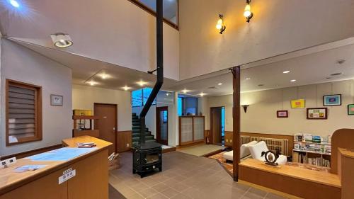a large living room with a stove in the middle at ペンション湖風 in Tateshina