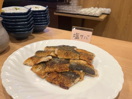 a white plate of food on a table at Sauna & Capsule Hotel Rumor Plaza in Kyoto