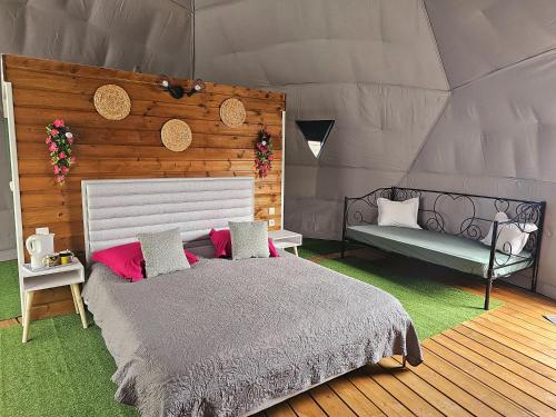 a bedroom with a bed and a bench in a tent at Domaine de l'Anse in Petite Île