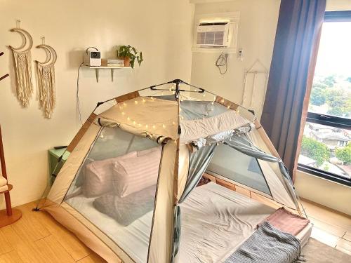 a tent in a room with a window at Condo Glamping at Vinia in Manila