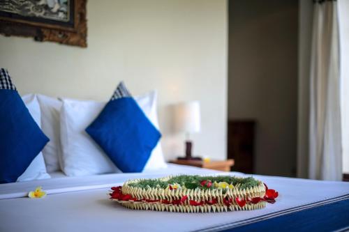 een bord eten op een bed bij Nang Ade Villa by Pramana Villas in Ubud