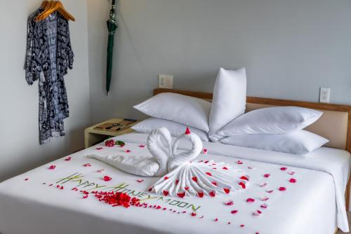 a bed with two white beds with flowers on it at The Up Hotel Phu Quoc Island - The Poolside Escape in Phu Quoc