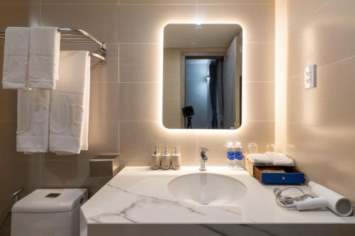 bagno con lavandino, specchio e servizi igienici di The Up Phu Quoc a Phu Quoc