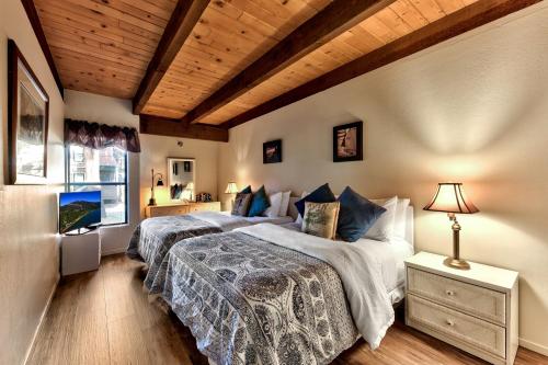 - 2 lits dans une chambre dotée de plafonds en bois dans l'établissement Lakeland Village 471 - Resort Magic 2BR Loft, à South Lake Tahoe