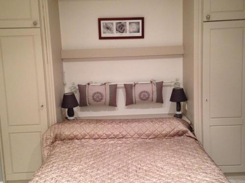 een slaapkamer met een bed met twee lampen erop bij Gîte confortable près du Zoo de Beauval, avec jardin - FR-1-491-428 in Meusnes