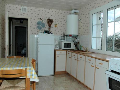 een keuken met een witte koelkast en een tafel bij Gîte Huisseau-sur-Cosson, 3 pièces, 4 personnes - FR-1-491-435 in Huisseau-sur-Cosson