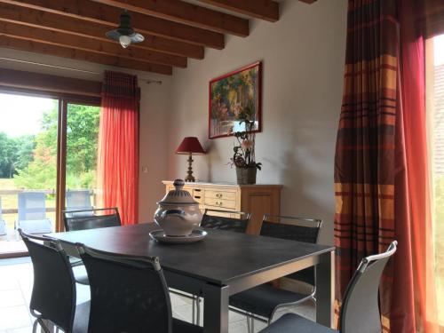 une salle à manger avec une table et des chaises dans l'établissement Maison spacieuse en Sologne avec grand jardin, proche randonnée, terrasse, parking privé - FR-1-491-437, à Chaon