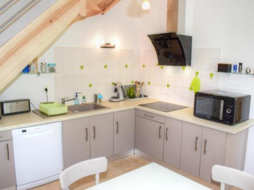 une cuisine avec un évier et un micro-ondes dans l'établissement Gîte familial tout confort avec jardin, vélos, et proche châteaux et Zoo de Beauval. - FR-1-491-434, à Saint-Georges-sur-Cher