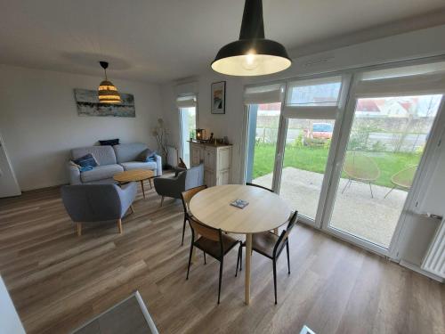 un salon avec une table et un canapé dans l'établissement Bel appartement moderne avec jardin et parking privatif - FR-1-675-38, à Wimereux