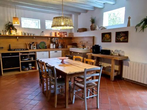 une cuisine avec une table et des chaises en bois dans l'établissement Gîte de charme en Sologne avec grand confort, 3 chambres, cheminée, jardin et promenades en forêt - FR-1-491-438, à Theillay