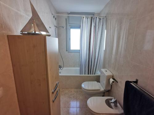 ein Bad mit einem WC, einem Waschbecken und einem Fenster in der Unterkunft Apartamento Llançà, 2 dormitorios, 4 personas - ES-89-137 in Llança