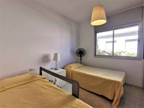 1 Schlafzimmer mit 2 Betten und einem Fenster in der Unterkunft Apartamento Llançà, 2 dormitorios, 4 personas - ES-89-137 in Llança