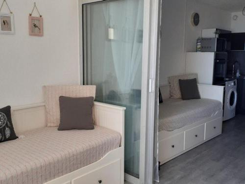 - une chambre avec 2 lits et un mur en verre dans l'établissement Appart rénové en bord de mer, ascenseur, parking, 50m plage - FR-1-782-49, au Barcarès