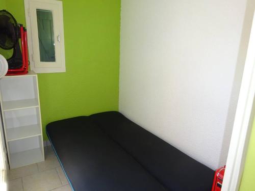 un lit dans une chambre avec un mur végétal dans l'établissement Studio Cabine avec Piscine, Parking et Proximité Commerces au Barcarès - FR-1-782-52, au Barcarès